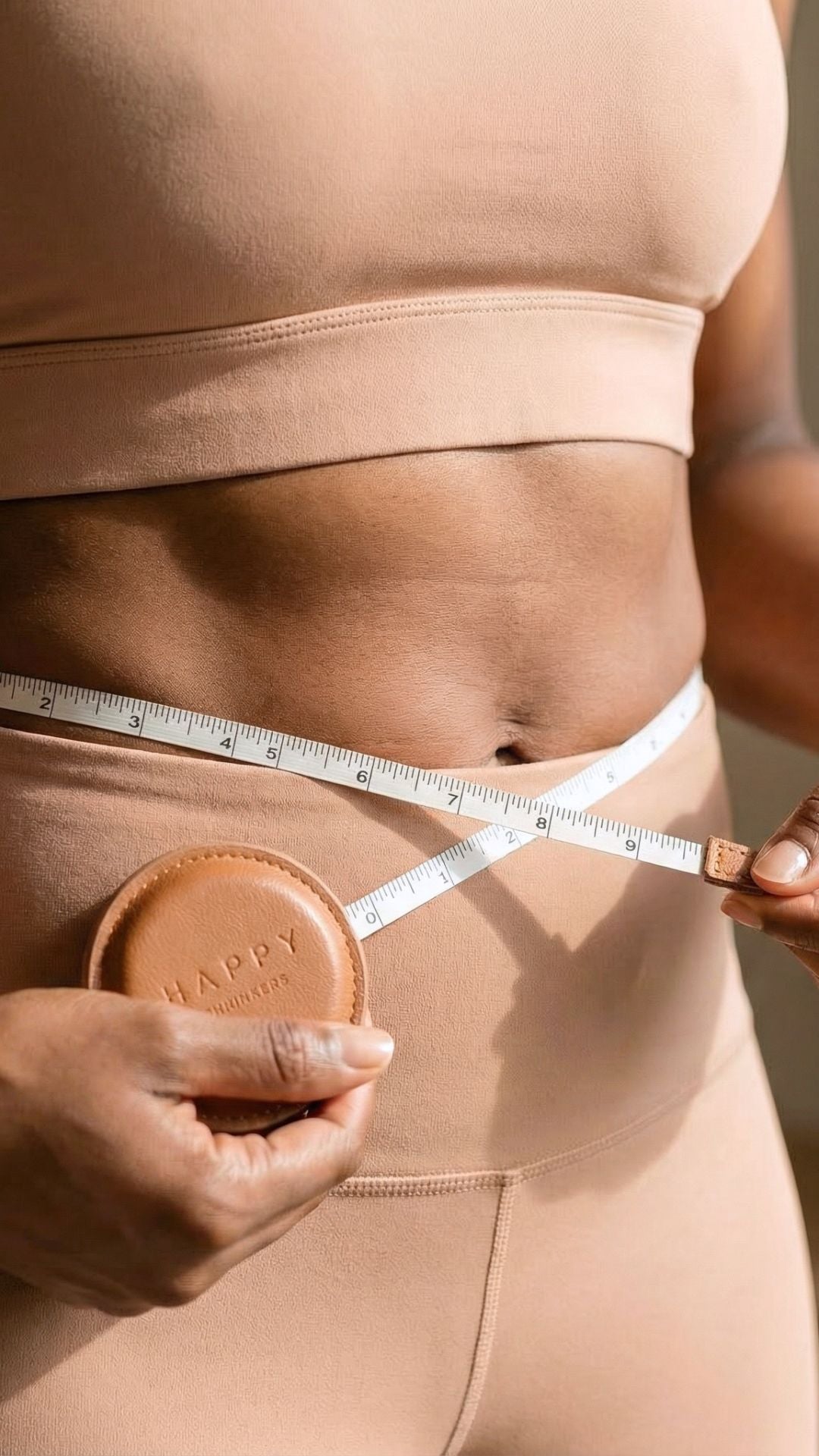 Smiling woman holding Happy Shrinkers fat loss drops — real results for women over 35